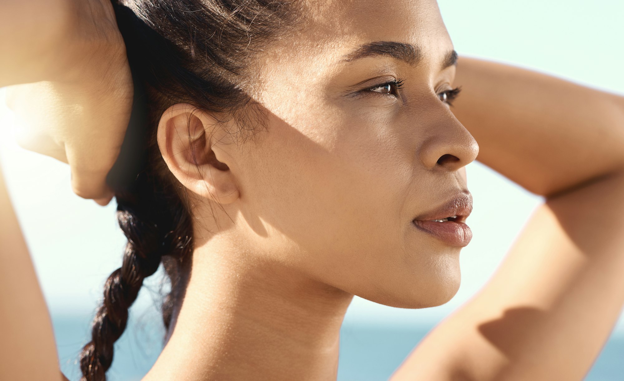 Close up of a beautiful female athletes face while taking a break while stretching and putting her