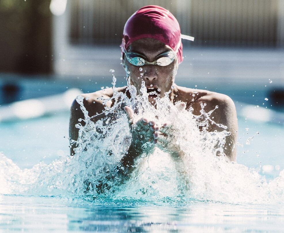 Swimmer splashing pool water on face